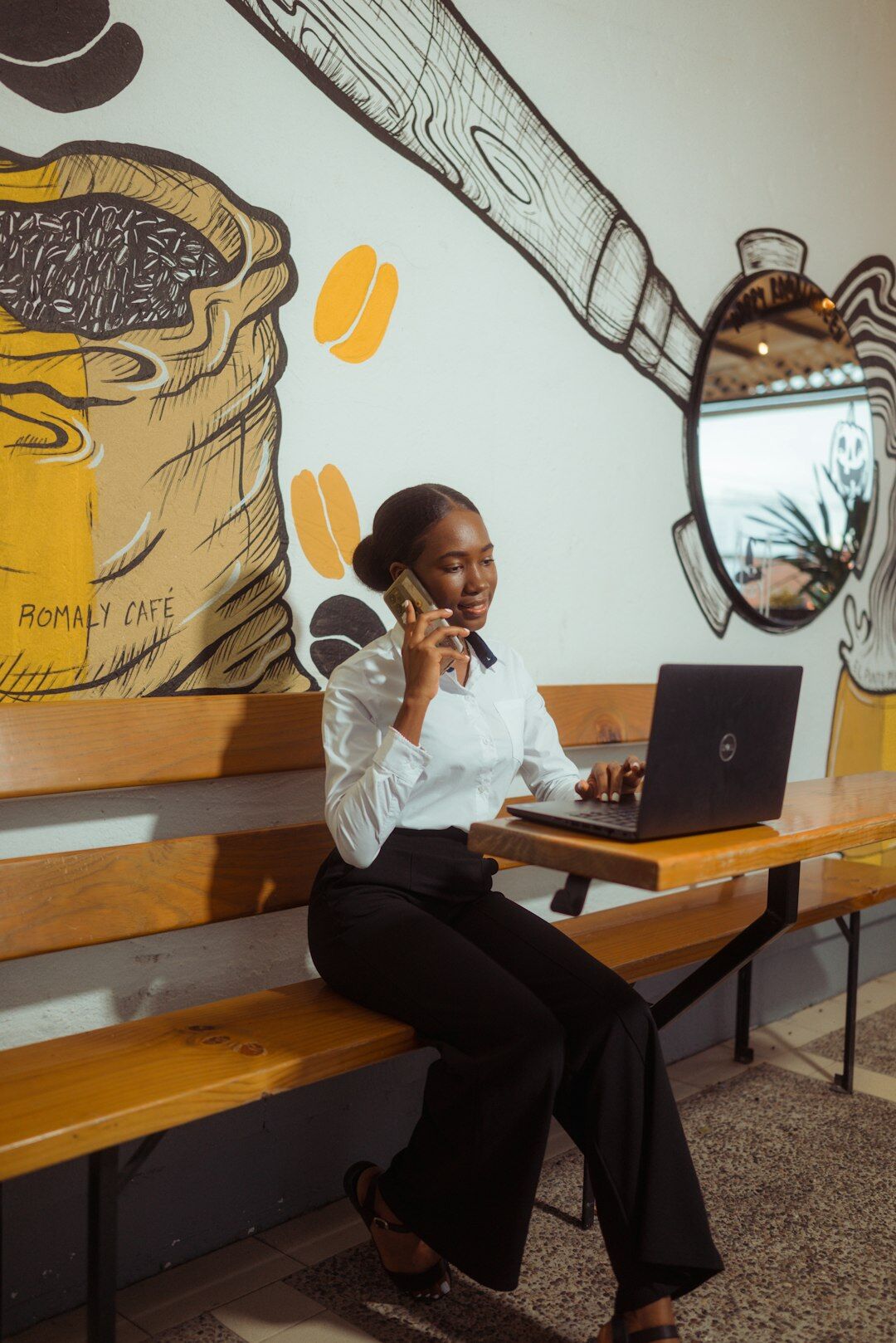 Brazilian woman smiling while holding a phone in a bright home office