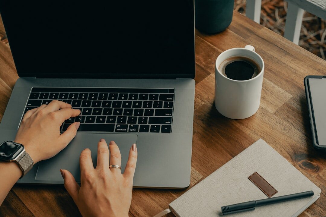Brazilian person writing a message on a laptop at a home desk